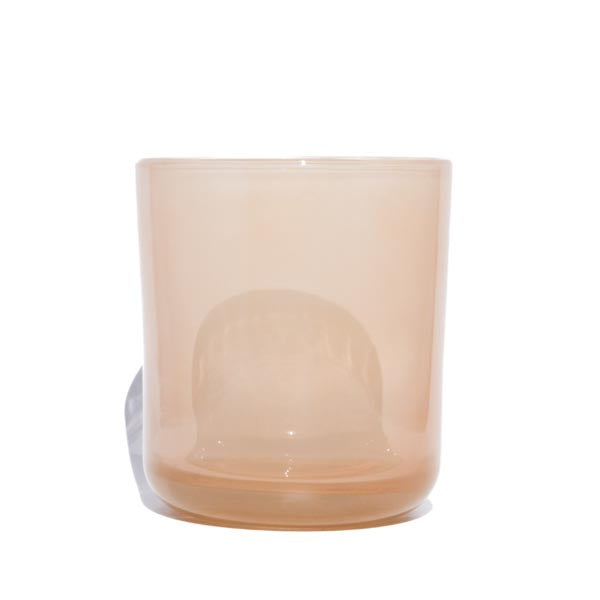 This image shows a cylindrical translucent glass candle container in a warm cream color. 