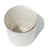 This image shows a cylindrical opaque glass candle vessel with a matte white finish.