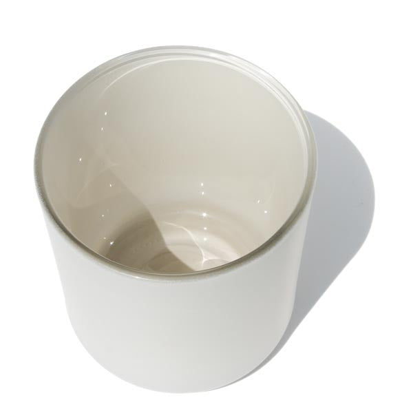 This image shows a cylindrical opaque glass candle vessel with a matte white finish.