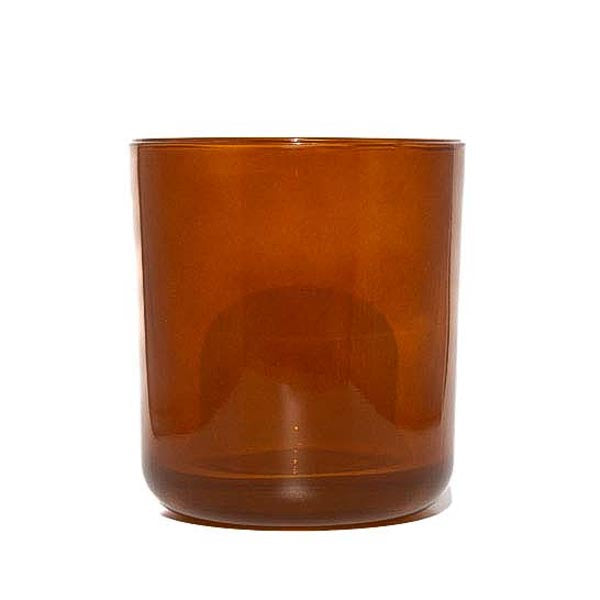 This image shows a cylindrical translucent glass candle container in an amber color.