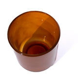 This image shows a cylindrical translucent glass candle vessel in an amber color.