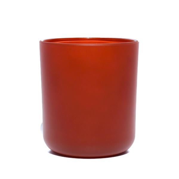 This image shows a cylindrical opaque glass candle container in a burnt orange color.