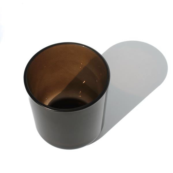 This image shows a cylindrical opaque glass candle vessel in a dark brown, espresso color.