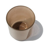 This image shows a cylindrical translucent  glass candle container in a mushroom brown color.