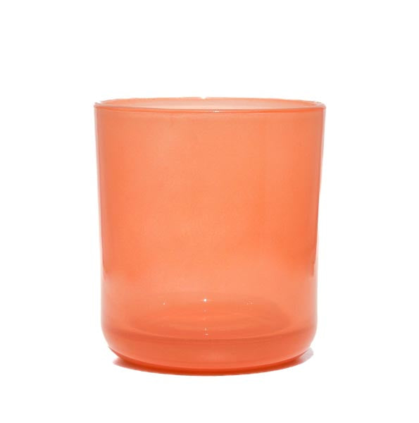 This image shows a cylindrical translucent glass candle container in a peach color.