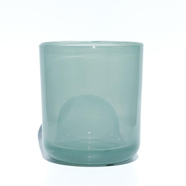 This image shows a cylindrical translucent glass candle container in a light blue-green sea-foam color.