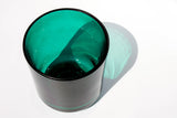 This image shows a cylindrical translucent glass candle vessel in an emerald green color.