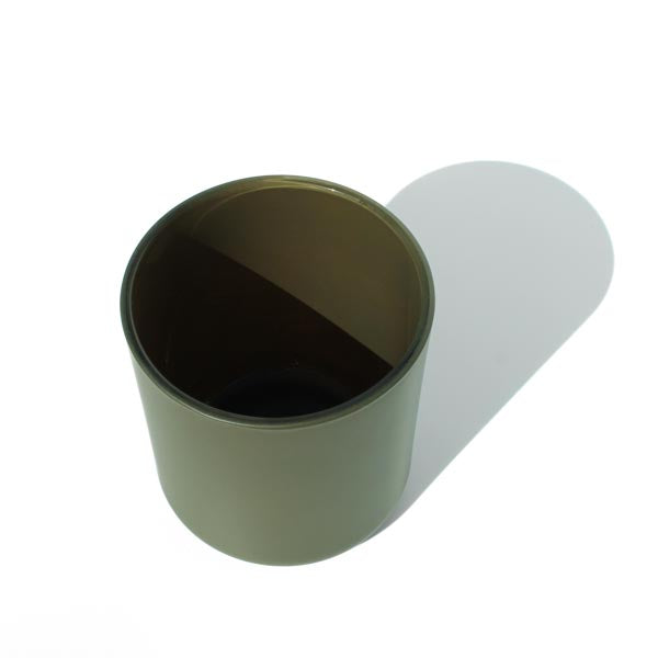 This image shows a cylindrical opaque  glass candle container in an olive green color.